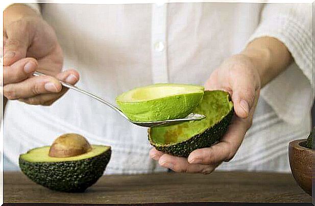 Person removing the pulp from the avocado.