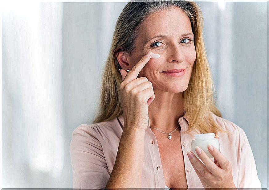 Woman applying cream to her face