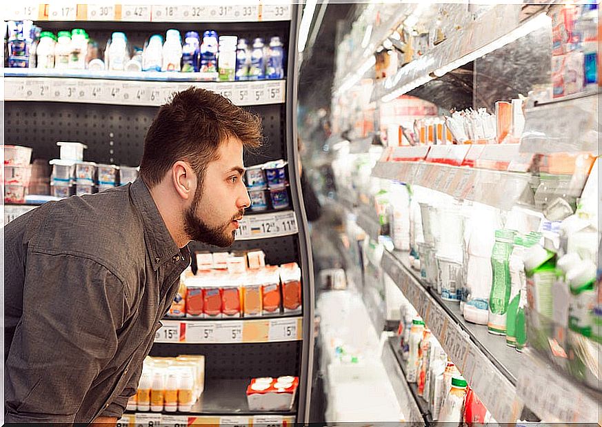 Man looking at dairy products in the supermarket.