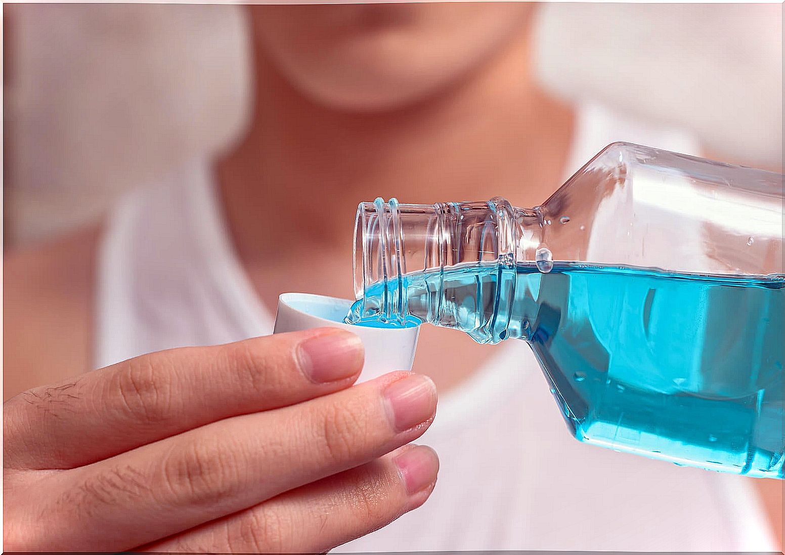 Person using mouthwash.